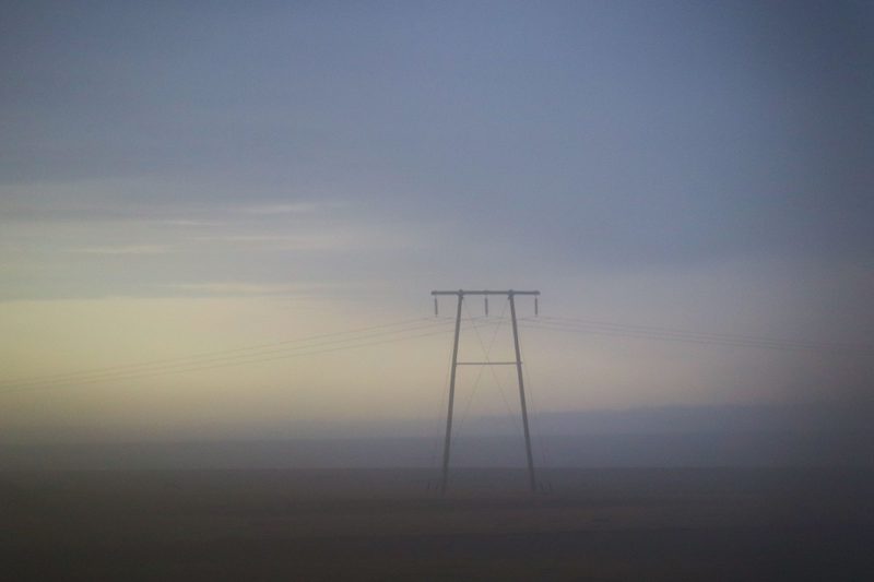Power line pylon in golden haze